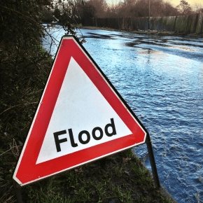 Flood warning road sign and water in the road