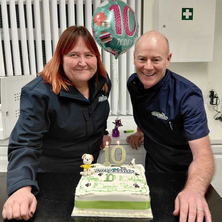 Vet Barry McNulty and Jasmine with a ten year birthday cake with a dog made out of icing on top